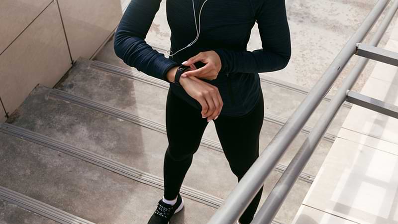 Woman checking heart rate using digital tracker on wrist