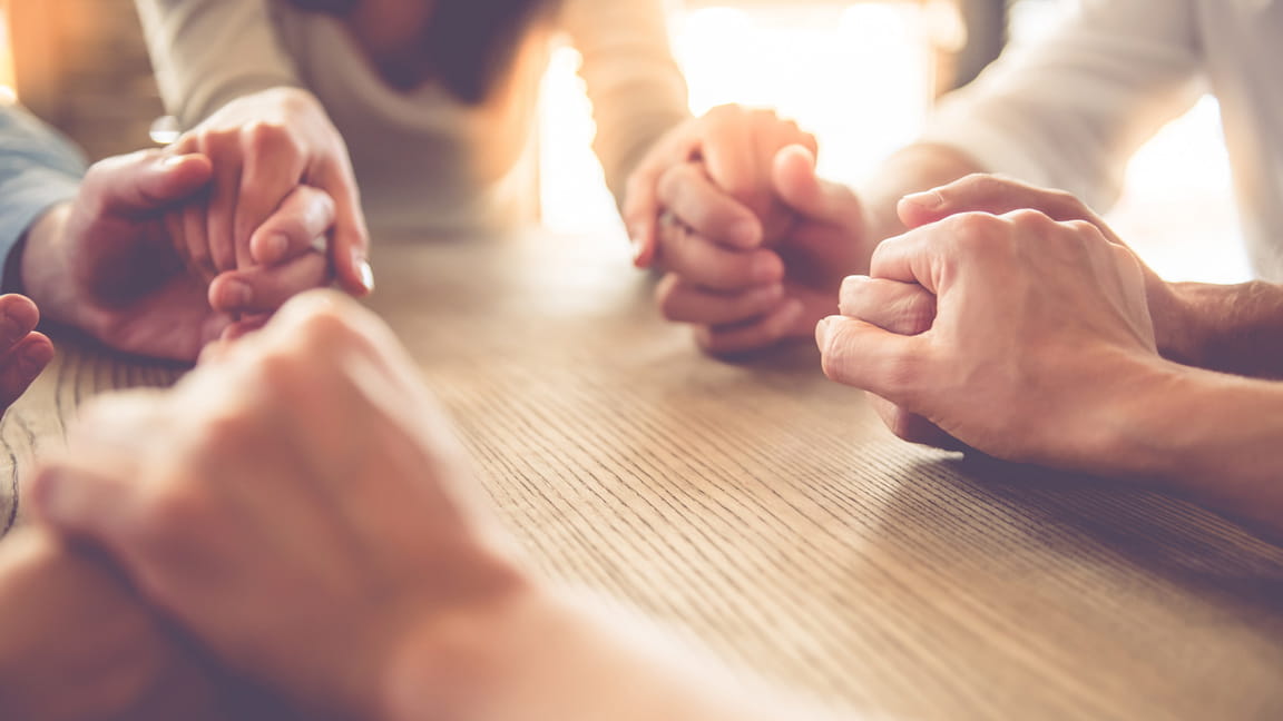 close up of friends holding hands in a circle