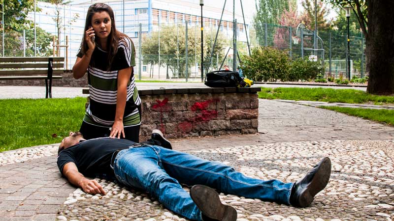 woman calling for help for man on ground