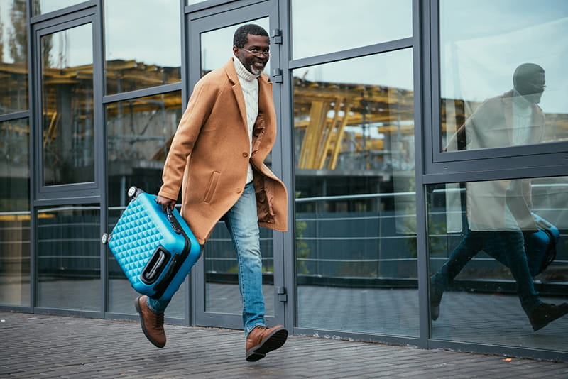 passenger at airport running with suitcase