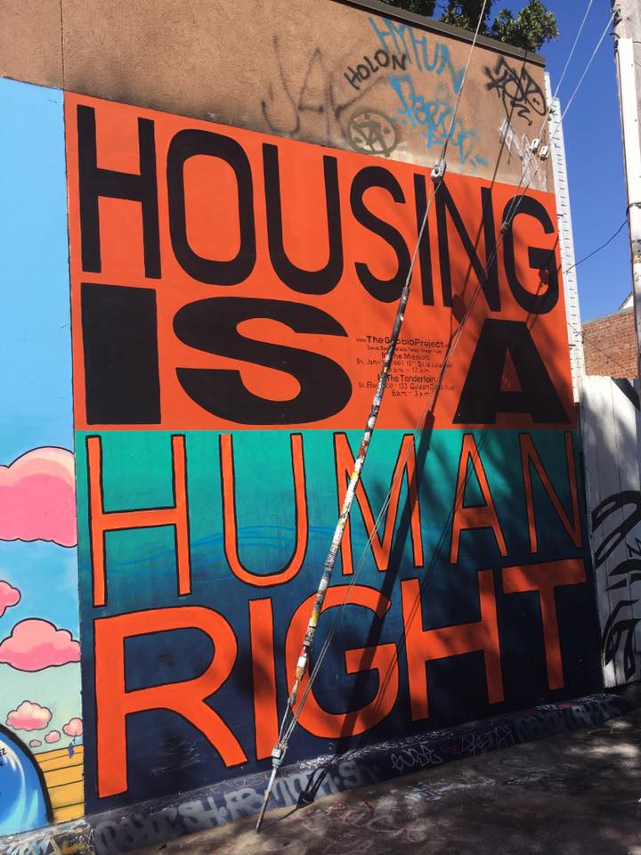 A sign painted on the side of a building that says, "Housing Is a Human Right"